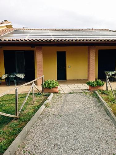 a yellow house with a pathway leading to it at Agriturismo dal Pastore in Follonica