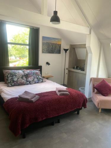 1 dormitorio con 1 cama grande con manta roja en De Bloesem en Cothen