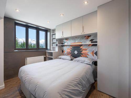 une chambre avec un grand lit blanc et une fenêtre dans l'établissement Appartement rénové avec accès direct aux pistes, 3 chambres, Courchevel 1850 - FR-1-564-75, à Courchevel