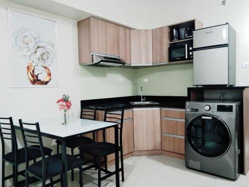 een keuken met een tafel en een wasmachine bij Avida Towers Riala T3 - Studio Unit 2nd Floor - 224 in Cebu City