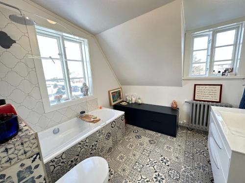 La salle de bains est pourvue d'une baignoire et d'un lavabo. dans l'établissement A New house that is a mix of an Historic House ( Torfhildur Hólms House ) and a new building in heart of Reykjavik on 3 levels, à Reykjavik