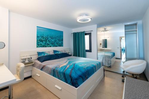 a bedroom with a bed and a desk and a bathroom at Calypso in Cotillo