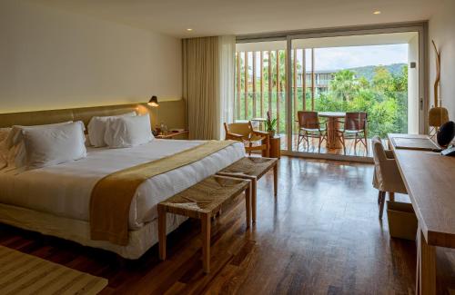 a hotel room with a bed and a table and chairs at Hotel Fasano Angra dos Reis in Angra dos Reis