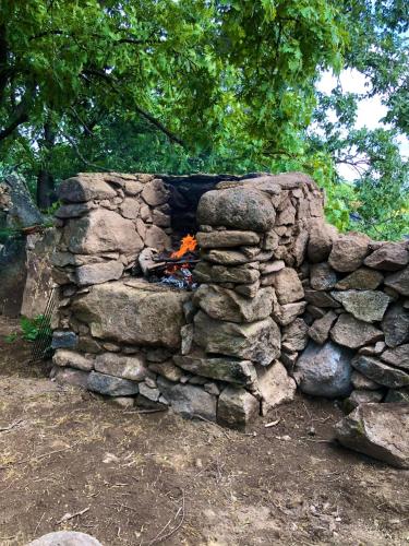 a stone fireplace with a fire in it at Vuelos de Montaña l in Montánchez