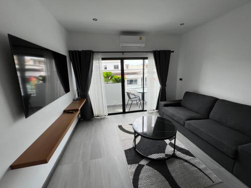 a living room with a couch and a glass table at ONE LODGE Pattaya in Pattaya