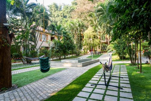 a park with two benches and a swing at The Greenwood Resort, Guwahati in Guwahati