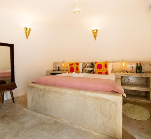 a bedroom with a large bed and a mirror at Sharazad Wonders Boutique in Zanzibar City