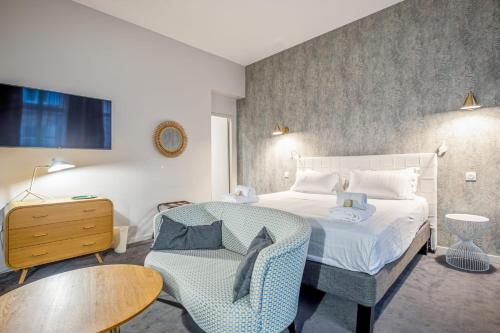 um quarto com uma cama, uma cadeira e uma mesa em Vallier Suite n18 - Exceptional suite in Bordeaux - Welkeys em Bordéus
