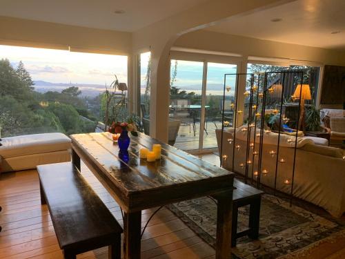een woonkamer met een houten tafel en een groot raam bij Magical Bay View in Oakland Hills in Oakland