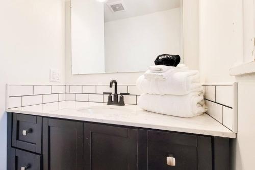um balcão de casa de banho com um lavatório e uma pilha de toalhas em Cozy and Spacious Home in Ogden em Ogden