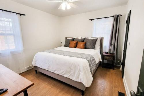 a white bedroom with a large bed with orange pillows at Cozy and Spacious Home in Ogden in Ogden