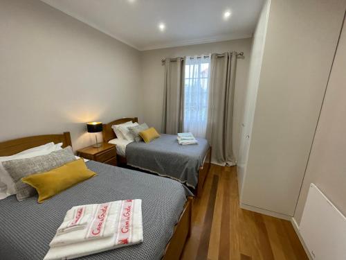 - 2 lits dans une petite chambre avec fenêtre dans l'établissement Casa da Grota, à Porto Moniz