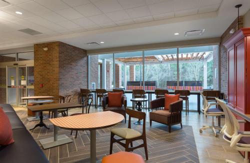 a restaurant with tables and chairs and windows at Home2 Suites By Hilton Charlotte Belmont, Nc in Belmont
