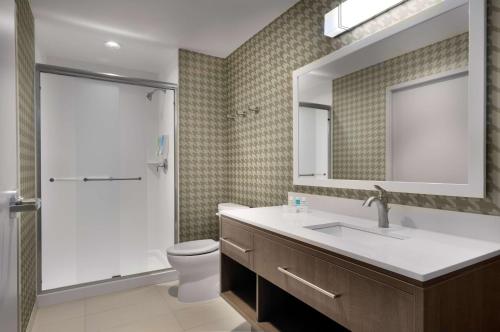 a bathroom with a toilet and a sink and a mirror at Home2 Suites By Hilton Charlotte Belmont, Nc in Belmont