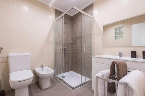 a bathroom with a shower and a toilet and a sink at Home Lisbon 2 in Lisbon
