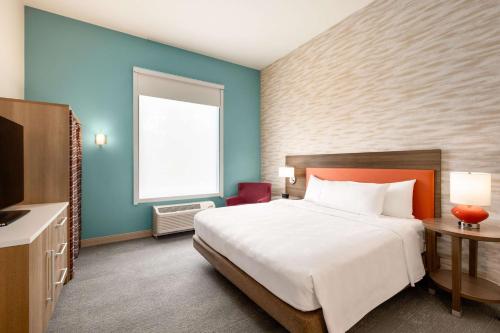Habitación de hotel con cama y TV en Home2 Suites By Hilton Bloomington Normal, en Normal