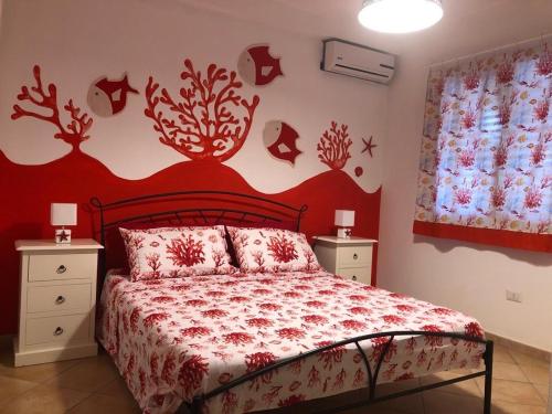 - une chambre dotée d'un lit avec un mur rouge dans l'établissement B&B Il Mirto Bianco, à San Giovanni Suergiu