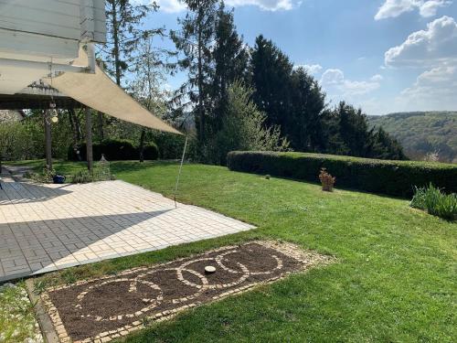 a garden with a sign in the grass at Maison Grande Fleur in Metterich