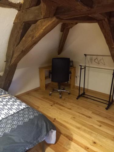 ein Schlafzimmer mit einem Schreibtisch und einem Stuhl im Dachgeschoss in der Unterkunft Chez Mimi in Trévol