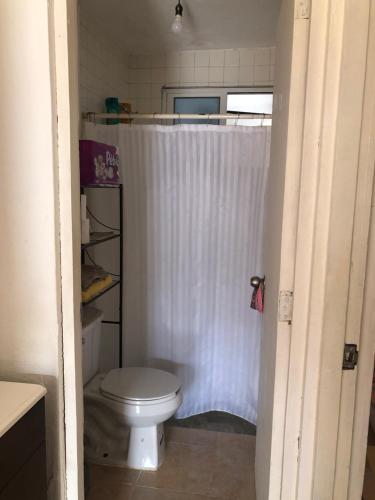 a bathroom with a toilet and a shower curtain at Depto Duplex Cancún (Cuarto) in Cancún