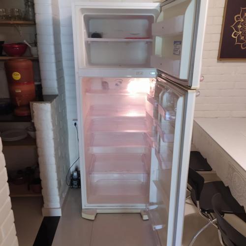 an empty refrigerator with its door open in a kitchen at Pousada Morro da Baleia in Alto Paraíso de Goiás