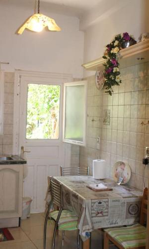 a kitchen with a table with chairs and a window at Athens Riviera coast apartment in Athens