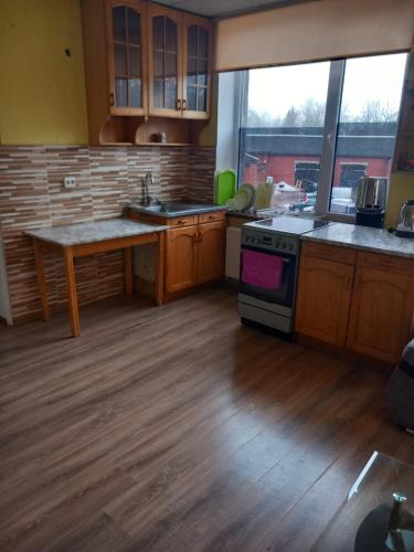 una cucina con armadi in legno, tavolo e forno di Balvu centrs Partizanu 10 a Balvi