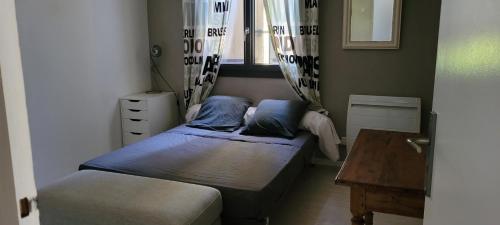 een kleine slaapkamer met 2 bedden en een tafel bij Les Cigales in Barbentane