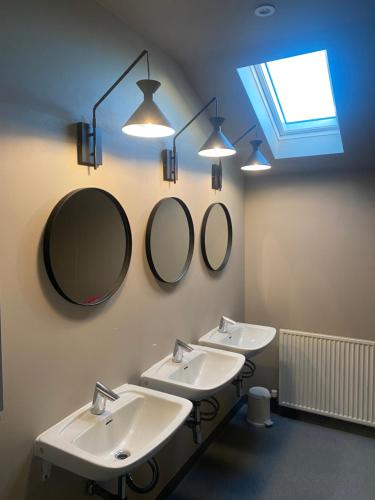 a bathroom with two sinks and two mirrors at Heppa Apartments in Höfn