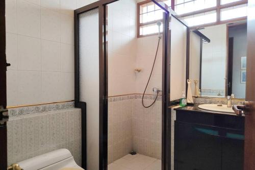 a bathroom with a shower and a toilet and a sink at Villa Rumah Oma Lembang 4 Kamar Strategis in Bongkor 1