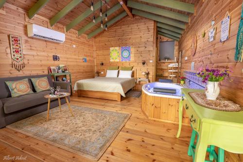 ein Schlafzimmer mit einem Bett und einer Badewanne in einem Zimmer in der Unterkunft Anat's Cabin הצימר של ענת in Kefar H̱ananya
