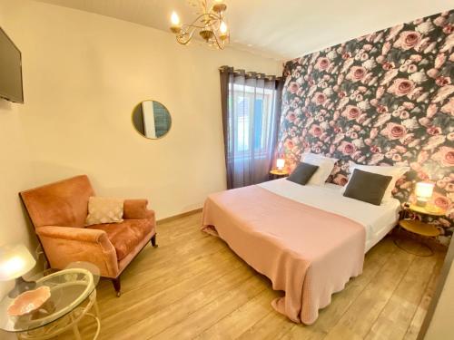 um quarto com uma cama e uma cadeira em L'Antre des Bastides em Saint-Martin-de-Villeréal
