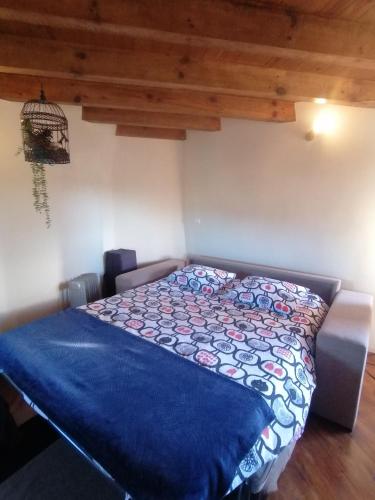 a bedroom with a bed with a blue comforter at The Windhouse in São Bartolomeu