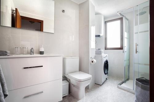 a white bathroom with a toilet and a shower at Hola Mar in Torrevieja