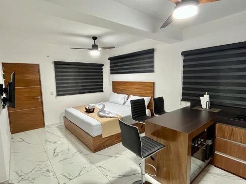 a bedroom with a bed and a desk and a deskablish at AHAU Playa in Playa del Carmen