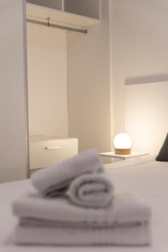 a pile of towels sitting on top of a bed at Babel Nueva Córdoba in Córdoba
