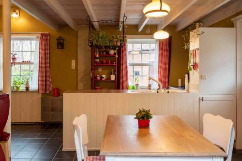 una cucina con tavolo, sedie e lavandino di Gîte les Mineurs a Zottegem