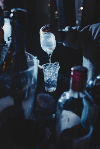 a person is pouring water into a glass with bottles at Smart Hotel Renzi in Folgarida