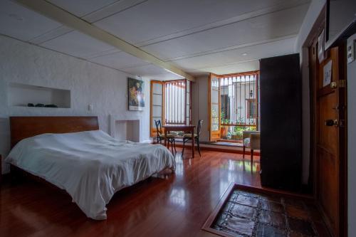 Un dormitorio con una cama y una mesa y sillas. en Apartaestudios La Candelaria, en Bogotá