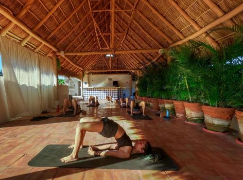 Una donna che fa una posa yoga in una stanza di Casa Lotería -Pueblito Sayulita- Colorful, Family and Relax Experience with Private Parking and Pool a Sayulita