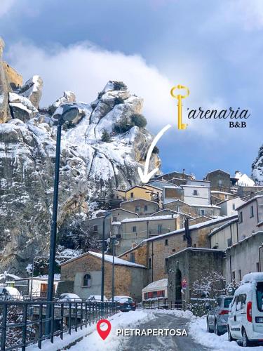 a city with a mountain in the background with snow at B&B L'Arenaria in Pietrapertosa