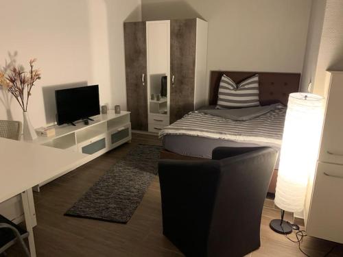 a bedroom with a bed and a desk with a television at Ländliche Idylle in Neu Bötzow
