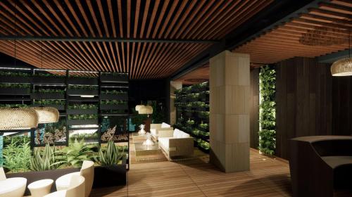 a lobby with white chairs and plants on the wall at The Greenwood Guwahati - A Luxury Boutique Hotel in Guwahati