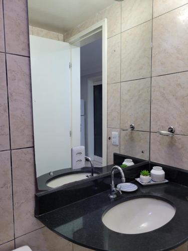 een badkamer met een wastafel en een grote spiegel bij Flat da Praia Natal in Natal