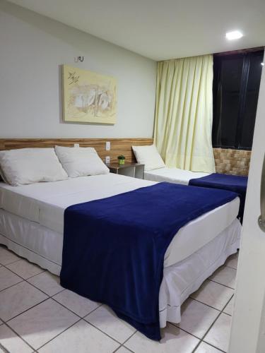 een slaapkamer met 2 bedden met blauwe en witte lakens bij Flat da Praia Natal in Natal