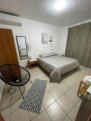 1 dormitorio con 1 cama y 1 silla en La villetta 2.0, en Rende