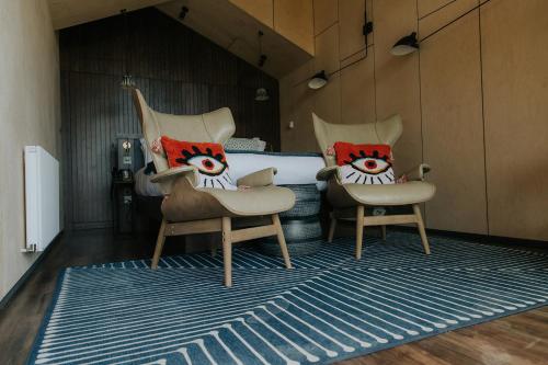two chairs with eyes on them sitting on a rug at Newton Hall in Chathill