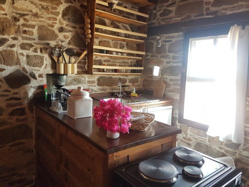 a kitchen with a stove and a stone wall at Chios Houses, beautiful restored traditional stone houses with an astonishing seaview in Volissos