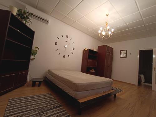 1 dormitorio con 1 cama y reloj en la pared en Veszprem city center, en Veszprém