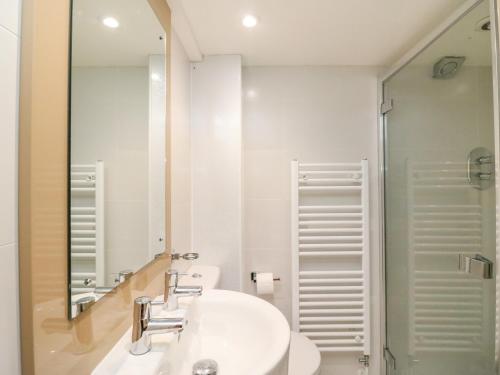 uma casa de banho branca com um lavatório e um espelho em Barley Mews em Weymouth